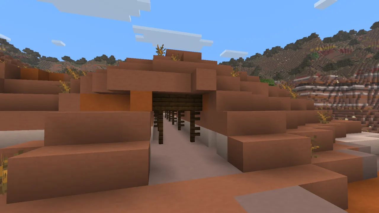 Surface Badlands mineshaft protruding from a red terracotta canyon wall with exposed dark oak wood pillars